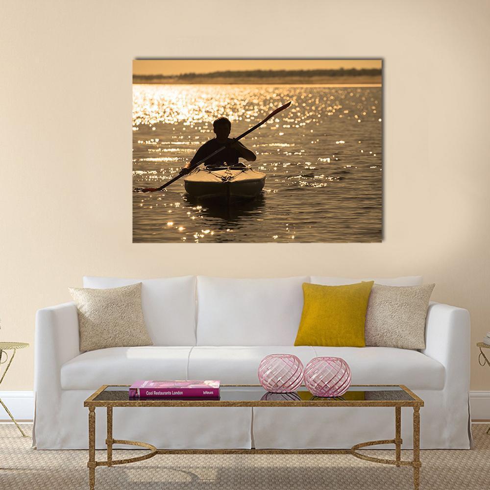 Kayaker Silhouette at Sunset Canvas Wall Art in black, orange and yellow, single panel hung on a wall