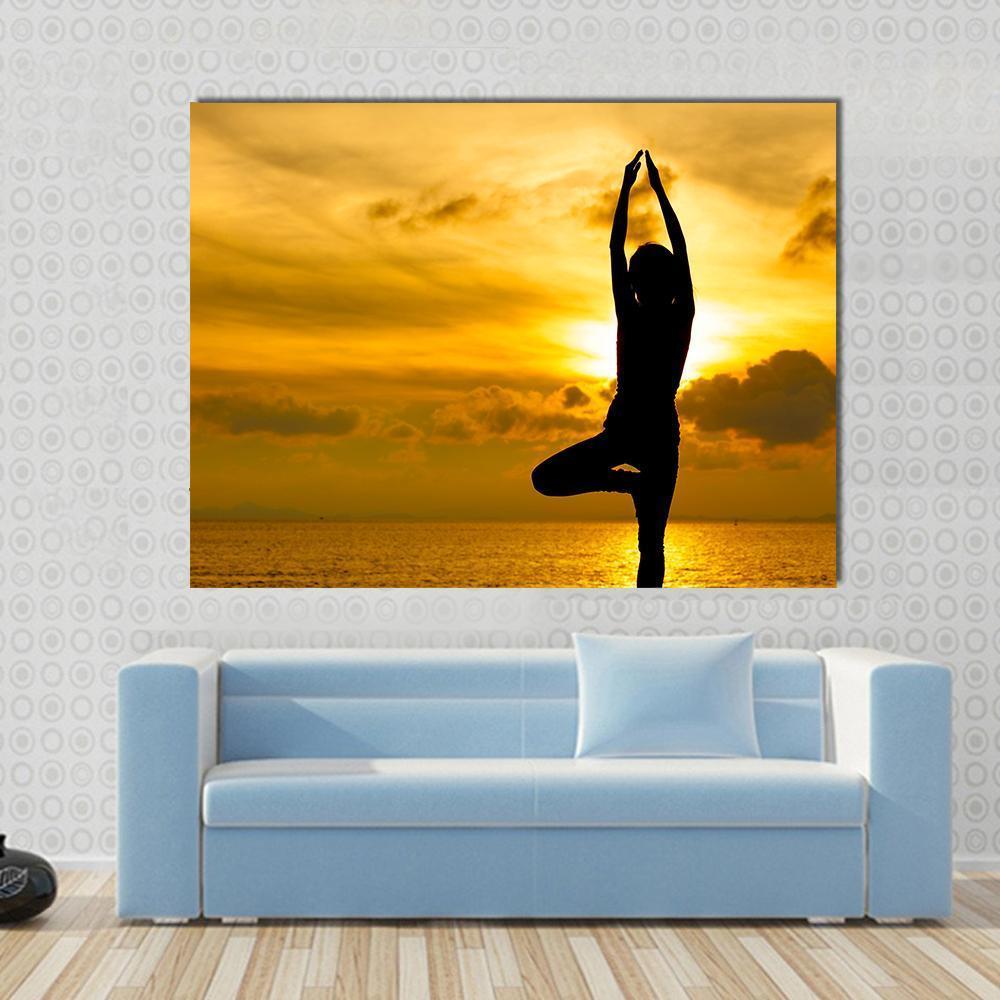 Silhouette of Yoga Woman in Sunset Canvas Wall Art in black, orange and yellow, single panel hung on a wall