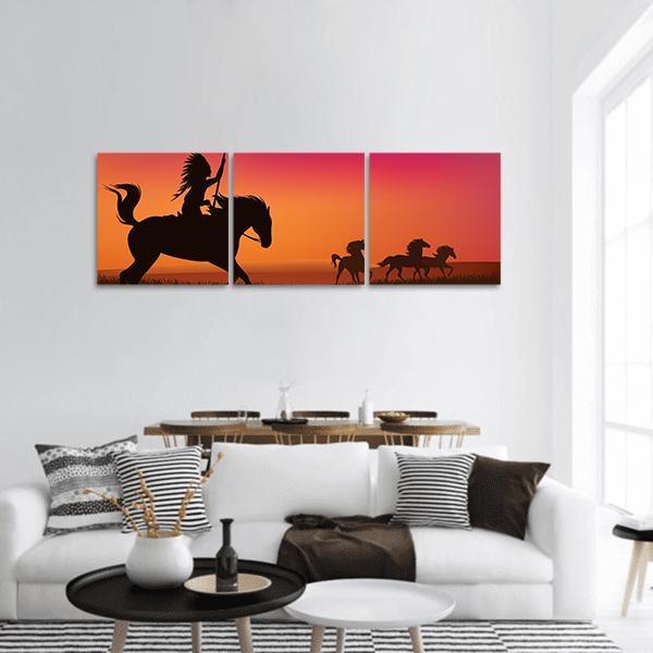 Native American Rider and Horses at Sunset Panoramic Canvas Wall Art in black, orange and pink, hung on a wall