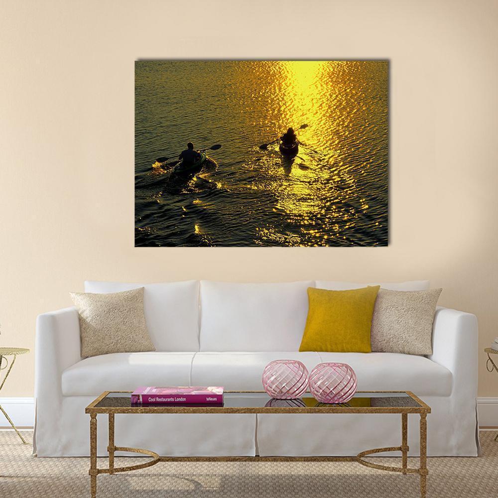 Kayakers Silhouetted on a Sunset Lake Canvas Wall Art in black, gold and yellow, single panel hung on a wall