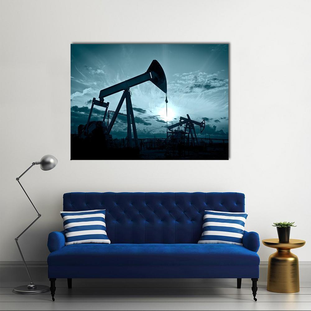Silhouetted Oil Pumps at Sunset Canvas Wall Art in black and blue, single panel hung on a wall