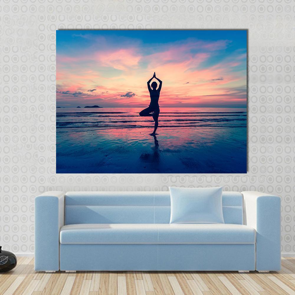 Silhouette of Woman in Yoga Pose at Sunset Canvas Wall Art in orange, blue and pink, single panel hung on a wall