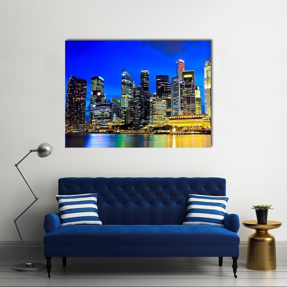 Singapore Night Skyline with Water Reflections Canvas Wall Art in black, yellow and blue, single panel hung on a wall