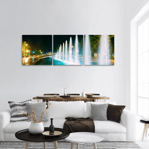 Singing and Dancing Fountains at Night Panoramic Canvas Wall Art in black, white and blue, hung on a wall