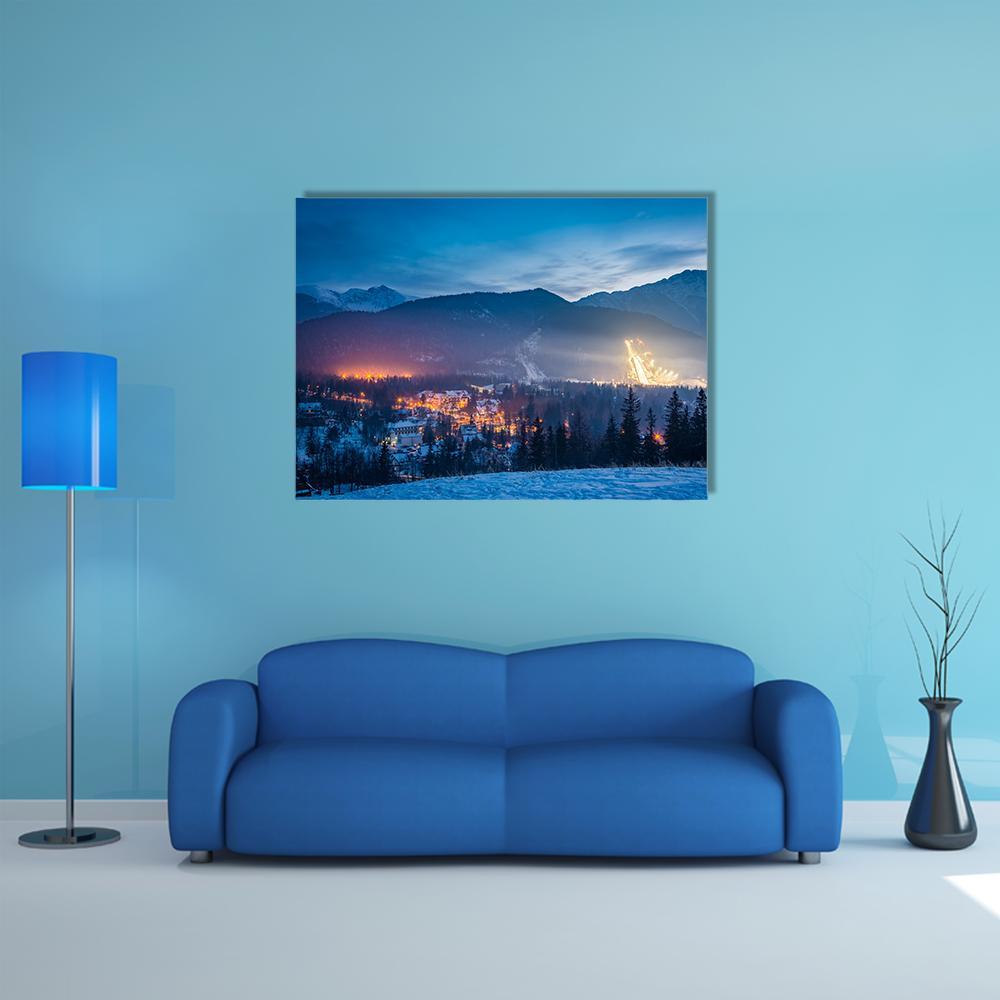 Ski Jump at Dusk Over Mountain Village Canvas Wall Art in white, orange and blue, single panel hung on a wall