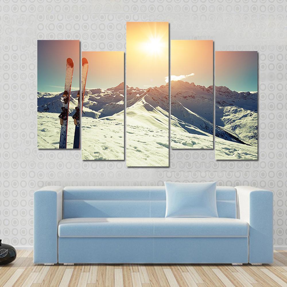 Skis in Snow at Mountains Canvas Wall Art in white, orange and blue, 5 panel Pop layout hung on a wall