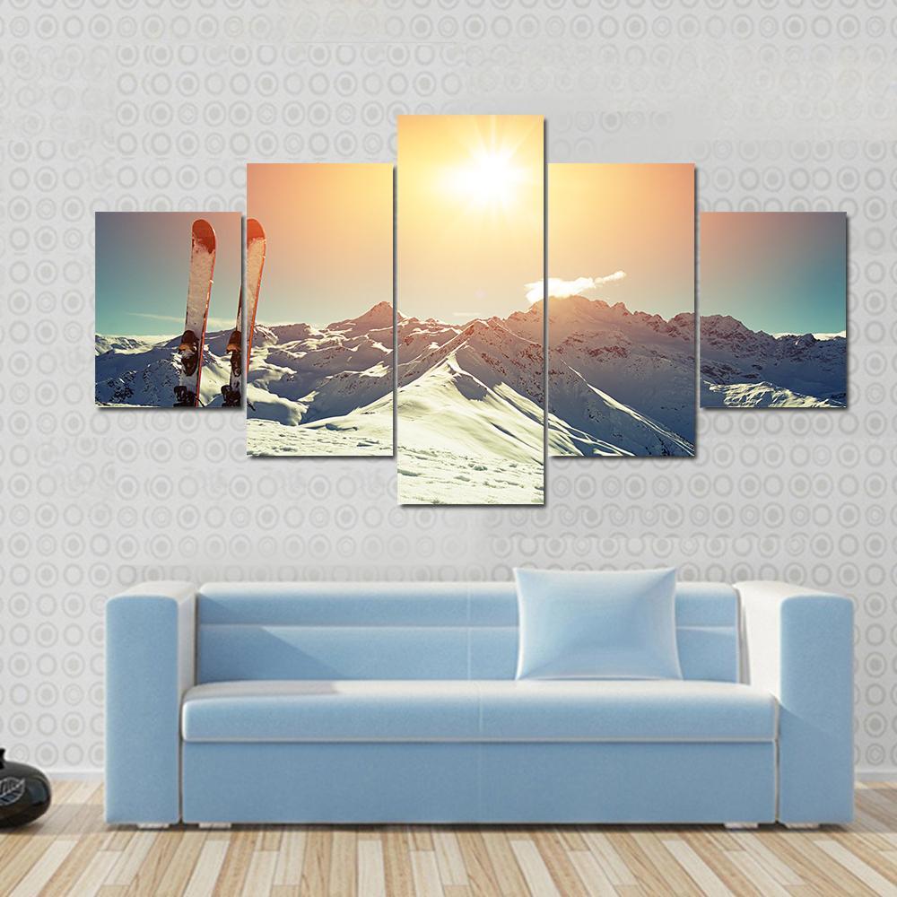Skis in Snow at Mountains Canvas Wall Art in white, orange and blue, 4 panel Pop layout hung on a wall