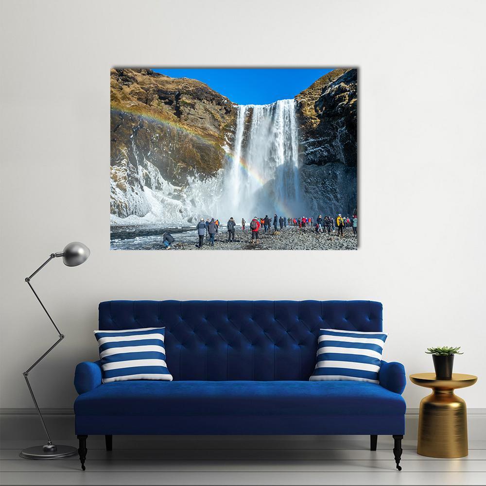 Skogafoss Winter Waterfall with Rainbow Canvas Wall Art in white, brown and blue, single panel hung on a wall