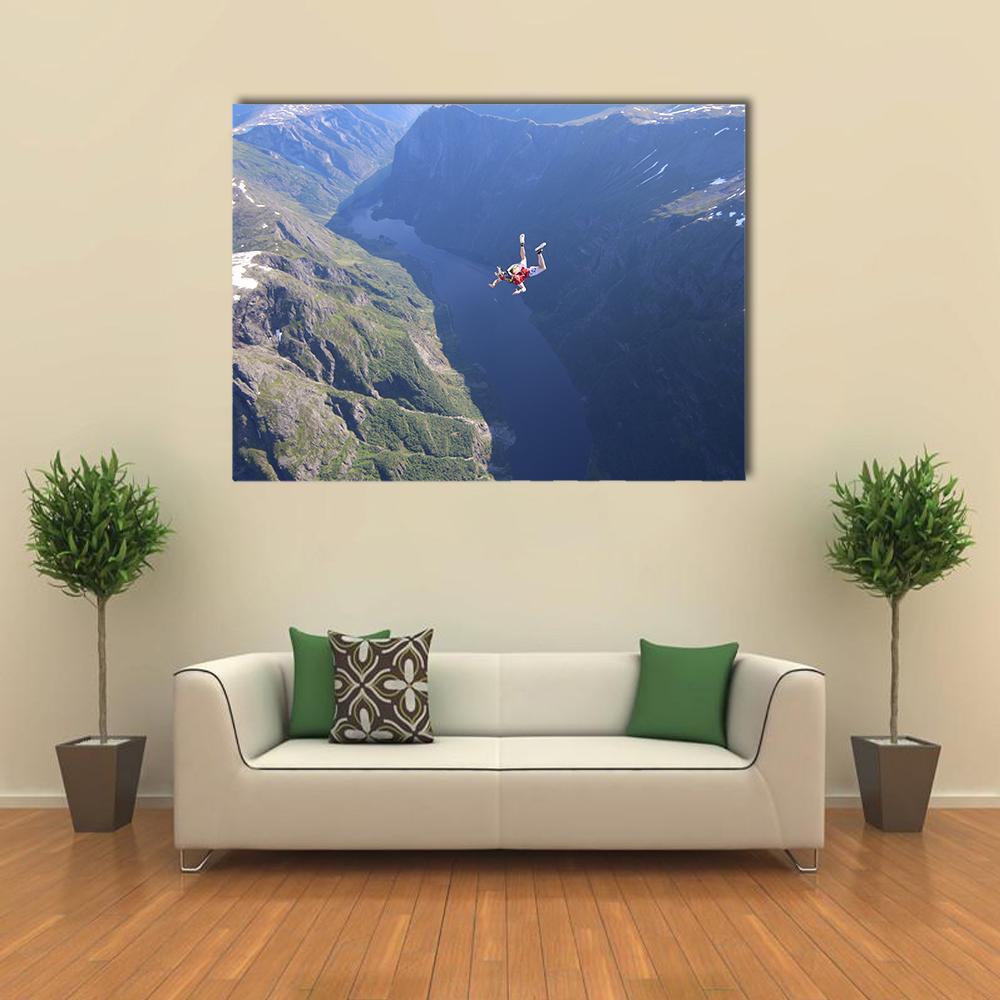 Skydiver Soaring Over Mountains Canvas Wall Art in gray, green and blue, single panel hung on a wall