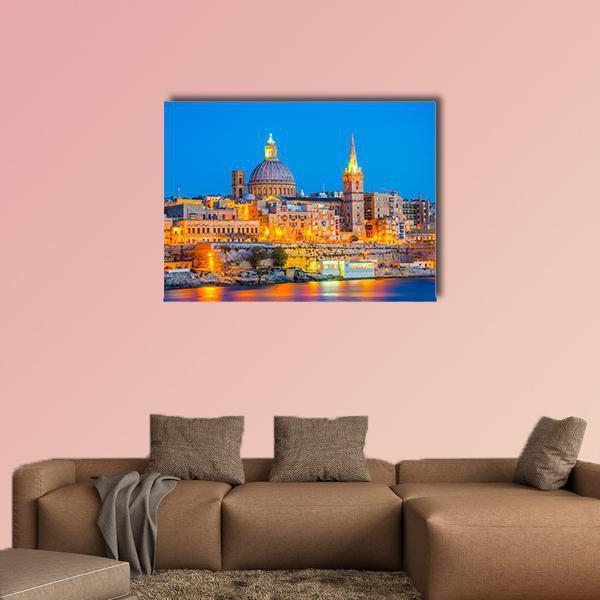 Malta Night Skyline with Harbor Reflections Canvas Wall Art in orange, yellow and blue, single panel hung on a wall