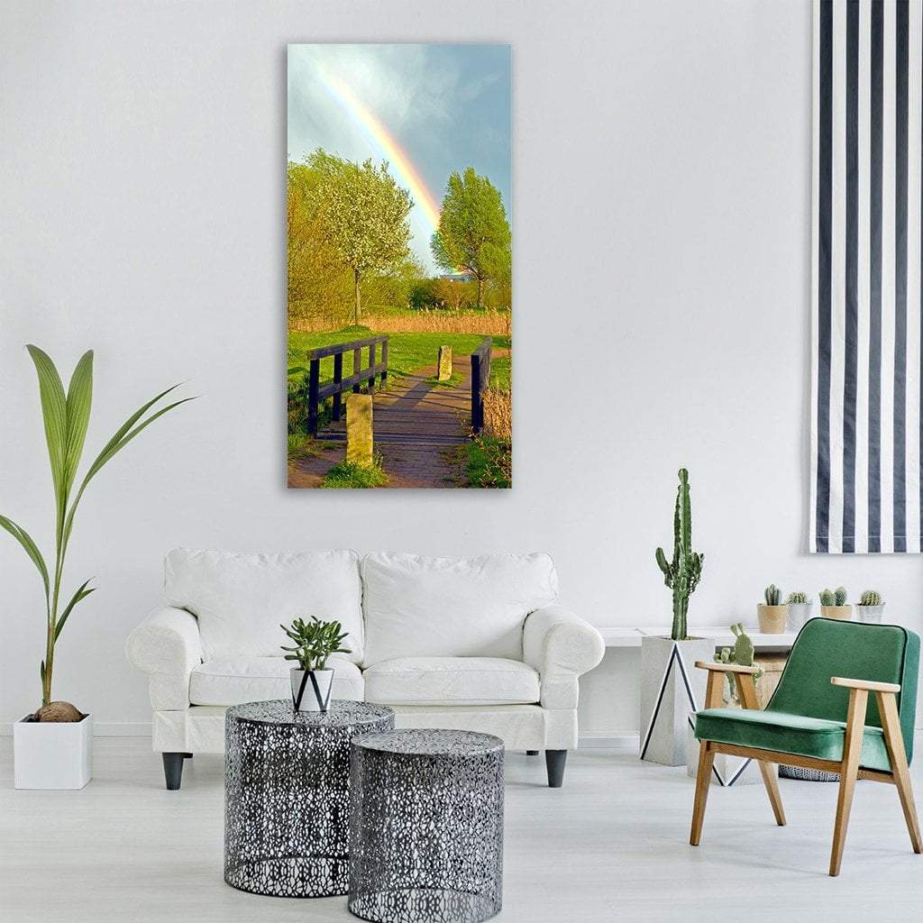 Small Bridge in Spring Fields Vertical Canvas Wall Art in yellow, green and blue, single vertical panel hung on a wall