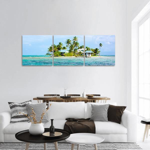 Tropical Island with Pier and Blue-roof Huts Panoramic Canvas Wall Art in white, green and blue, hung on a wall