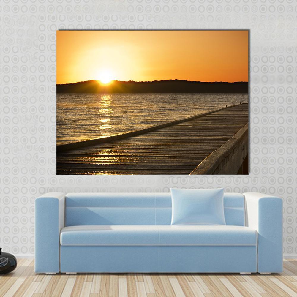 Small Jetty Sticks Out Onto the Lake at Sunrise Canvas Wall Art in brown, orange and yellow, single panel hung on a wall