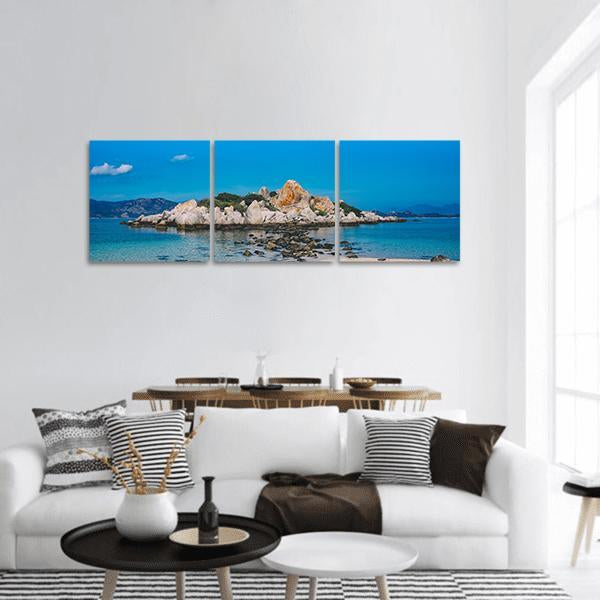 Small Rocky Island Near Beach Panoramic Canvas Wall Art in beige, brown and blue, hung on a wall