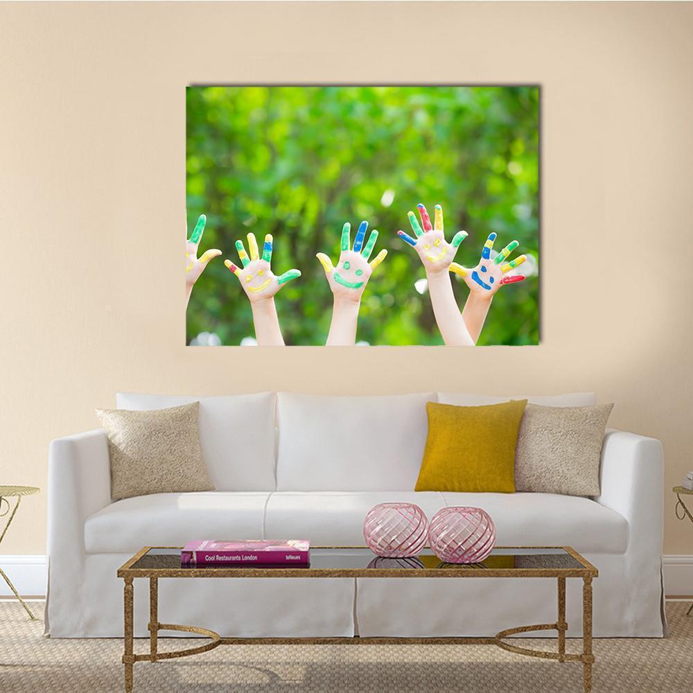 Smiley Painted Hands Canvas Wall Art in green and multicolor, single panel hung on a wall