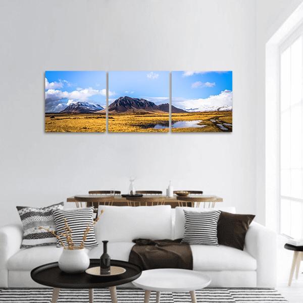 Snaefellsjoekull Snow-capped Mountains and Golden Field Panoramic Canvas Wall Art in white, yellow and blue, hung on a wall