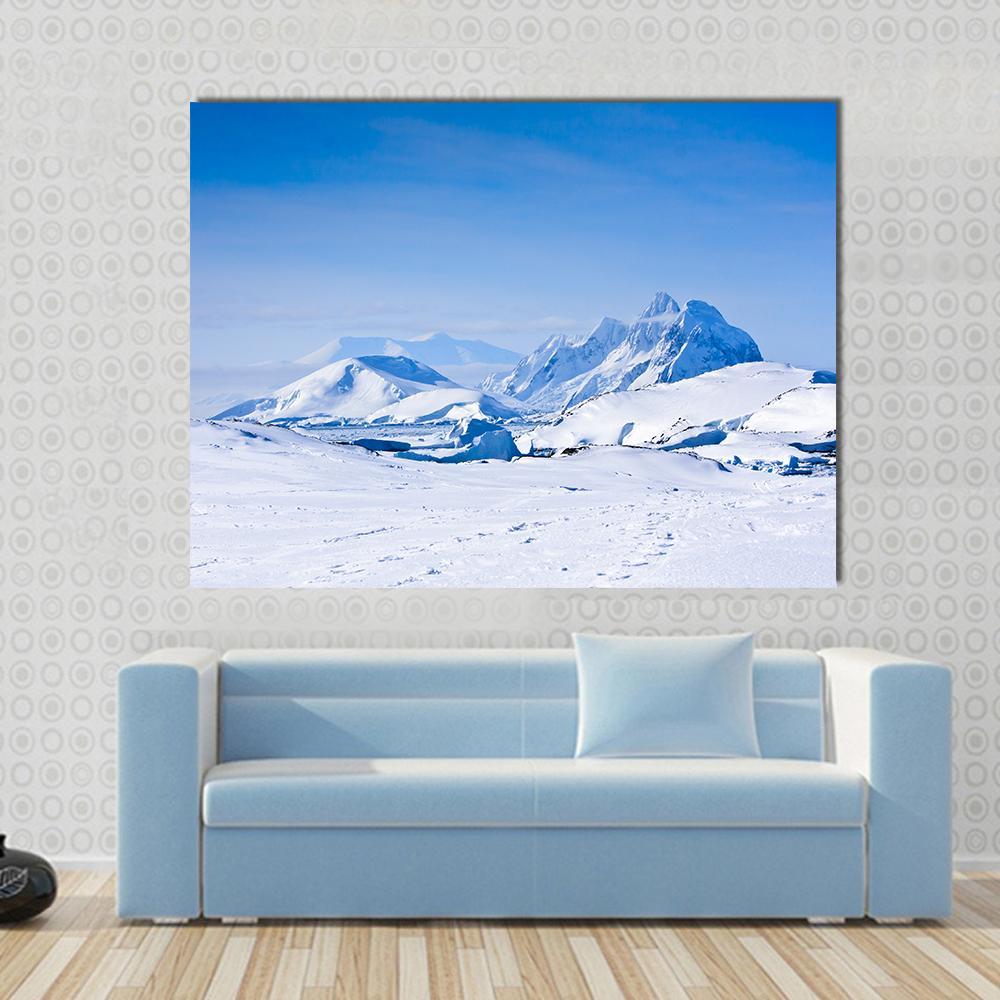 Snow Capped Mountains in Antarctica Canvas Wall Art in white and blue, single panel hung on a wall