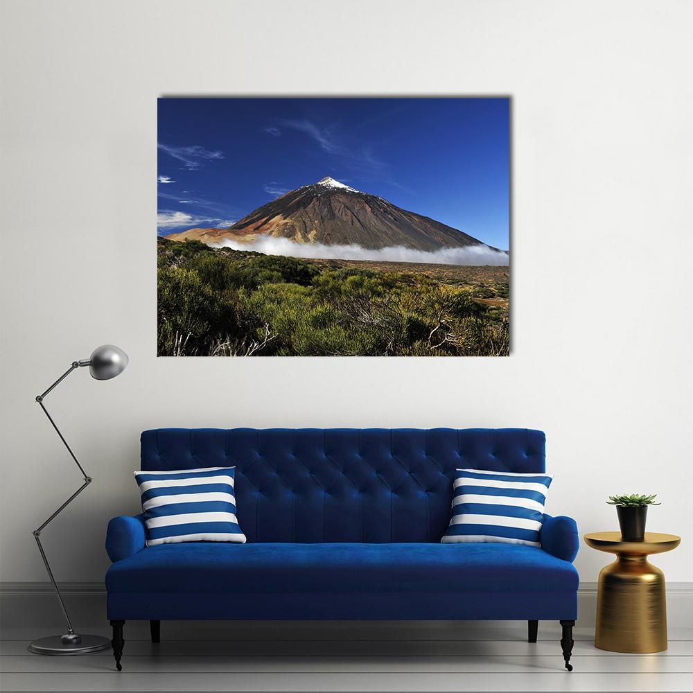 Snow-capped Volcanic Peak Canvas Wall Art in brown, green and blue, single panel hung on a wall