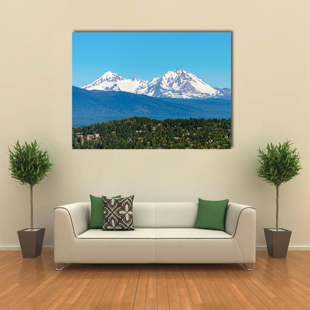 Snow Covered Three Sisters Mountains Canvas Wall Art in white, green and blue, single panel hung on a wall