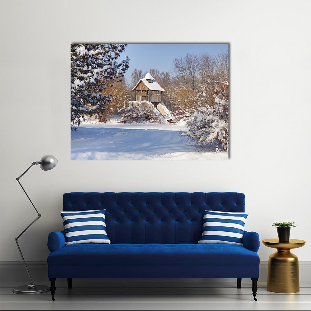 Winter Scene with Snow-covered Trees Canvas Wall Art in white, brown and blue, single panel hung on a wall
