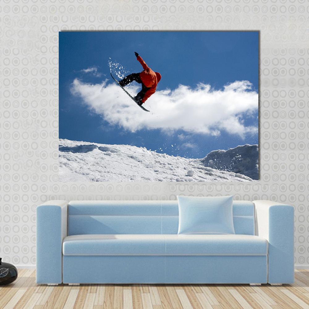 Snowboarder Mid-air Over Mountain Canvas Wall Art in white and blue, single panel hung on a wall