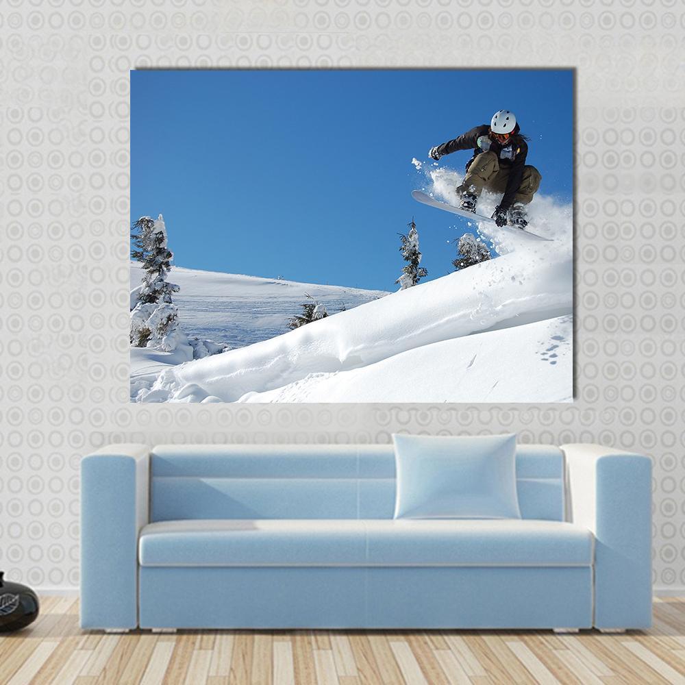 Snowboarder Mid-jump Against Blue Sky Canvas Wall Art in white and blue, single panel hung on a wall