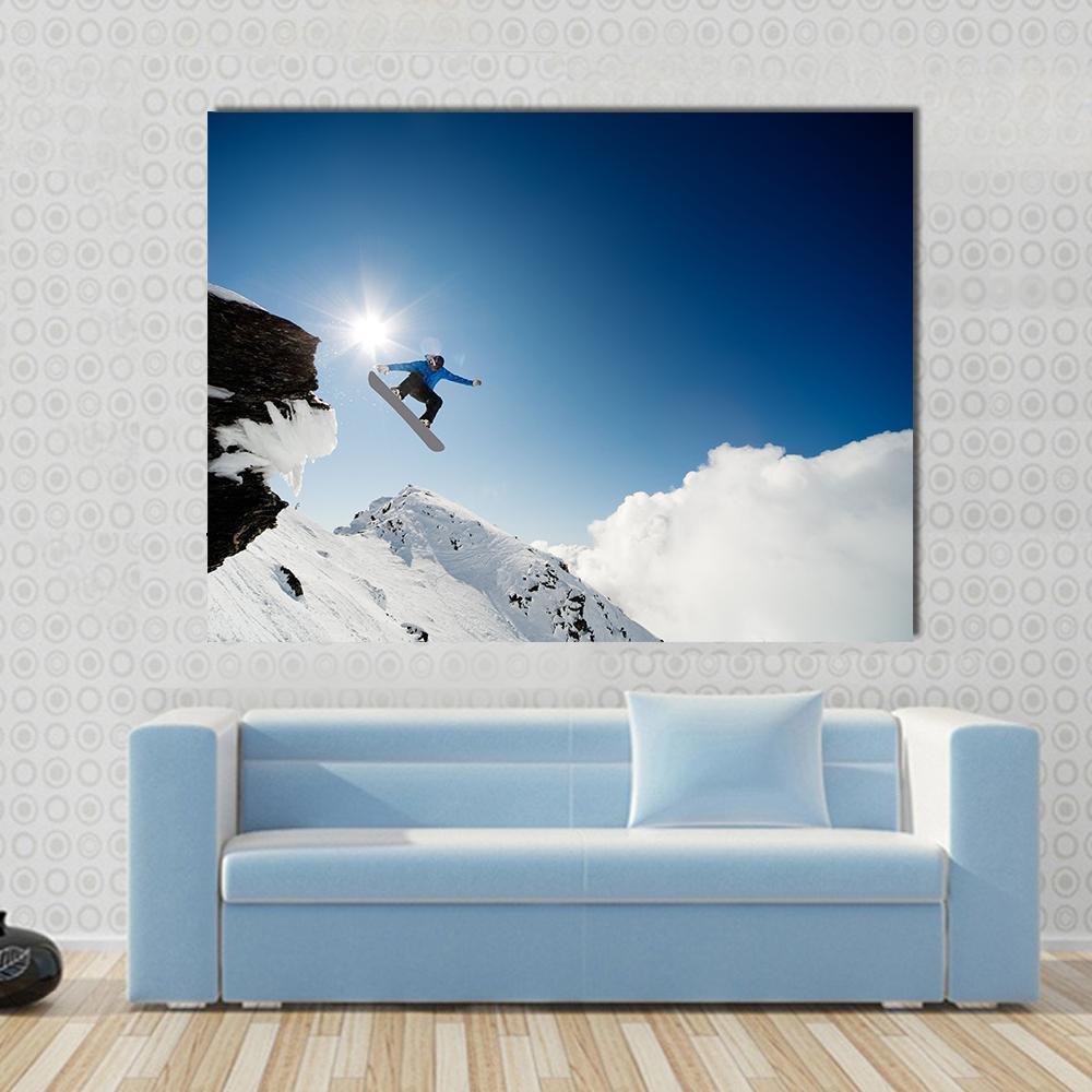 Snowboarder Mid-air After Rock Drop Canvas Wall Art in white and blue, single panel hung on a wall