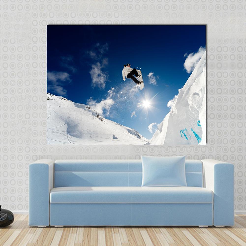 Snowboarder Jumping Through the Air Canvas Wall Art in white and blue, single panel hung on a wall