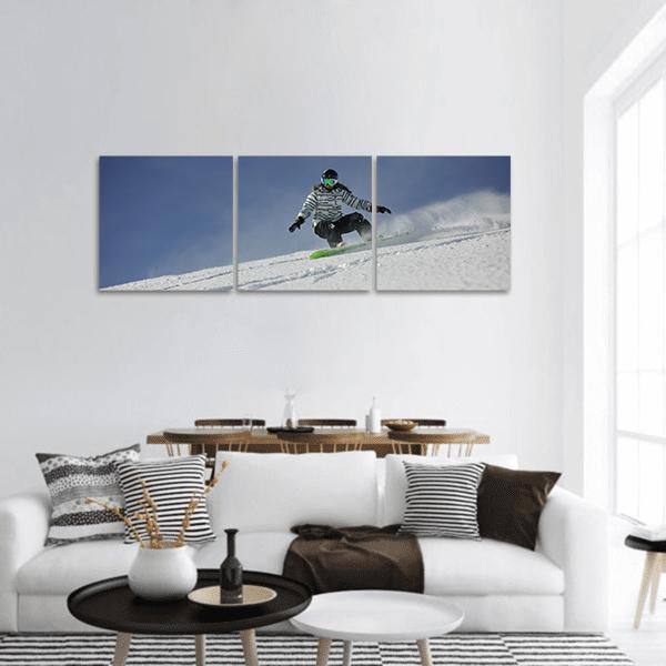 Snowboarder Racing Downhill Panoramic Canvas Wall Art in white and blue, hung on a wall