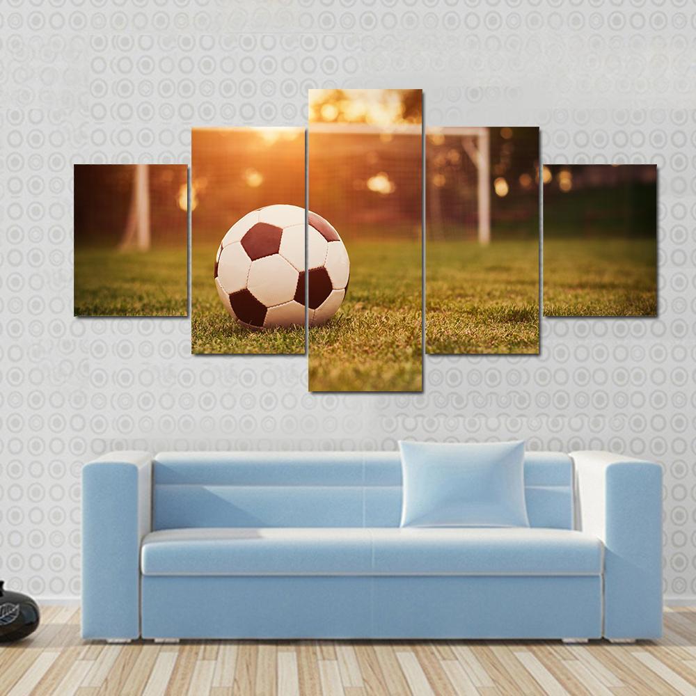 Soccer at Sunset Canvas Wall Art in orange, yellow and green, 5 panel Star layout hung on a wall