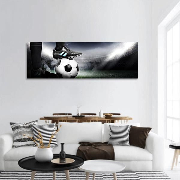 Soccer Cleat and Ball Under Stadium Lights Panoramic Canvas Wall Art in black, white and gray, hung on a wall