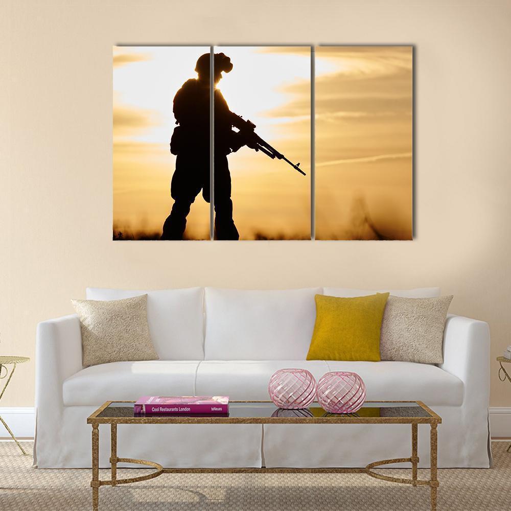 Soldier Silhouette at Sunset Canvas Wall Art in black, orange and yellow, 3 panel horizontal set hung on a wall
