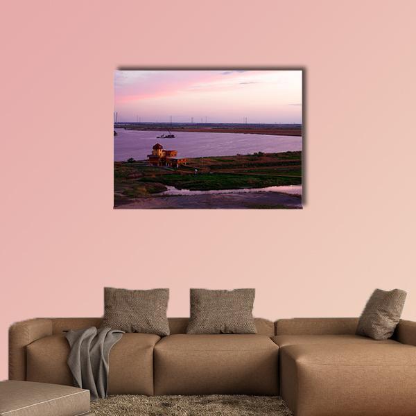 Sunset Over River Shipyard Canvas Wall Art in orange, purple and pink, single panel hung on a wall
