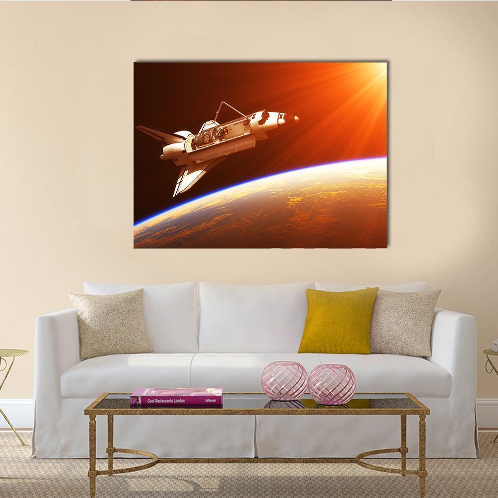 Space Shuttle Orbiting Earth at Sunrise Canvas Wall Art in black, orange and yellow, single panel hung on a wall