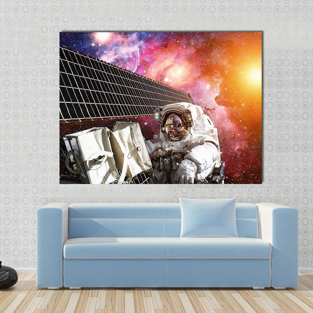 Space Station and Astronaut in Outer Space Canvas Wall Art in black, pink and multicolor, single panel hung on a wall