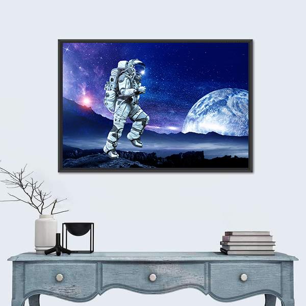 Astronaut Running Beneath a Large Moon Canvas Wall Art in black, white and blue, framed canvas, product view on a white background