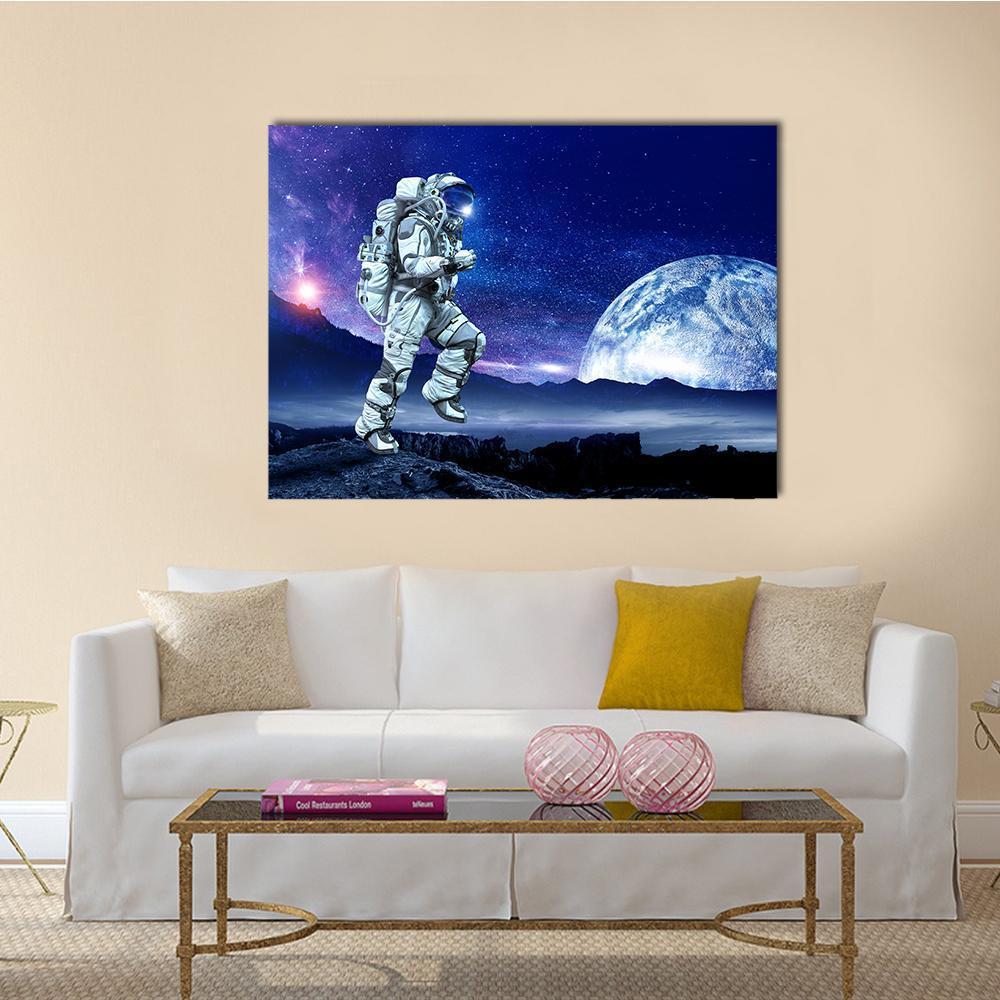 Astronaut Exploring Cratered Planet Canvas Wall Art in black, blue and purple, single panel hung on a wall