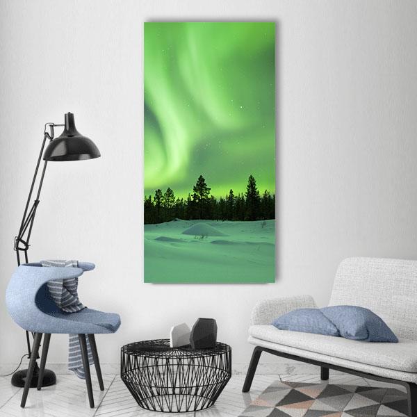 Aurora Borealis Over Snowy Pine Forest Vertical Canvas Wall Art in white and green, hung on a wall