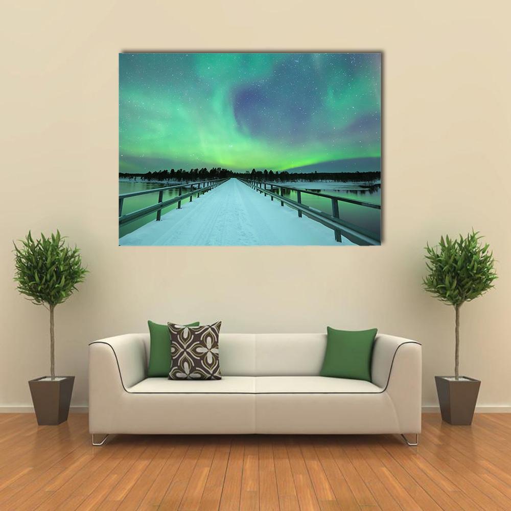 Northern Lights Over Snowy Bridge and River Canvas Wall Art in white, green and blue, single panel hung on a wall