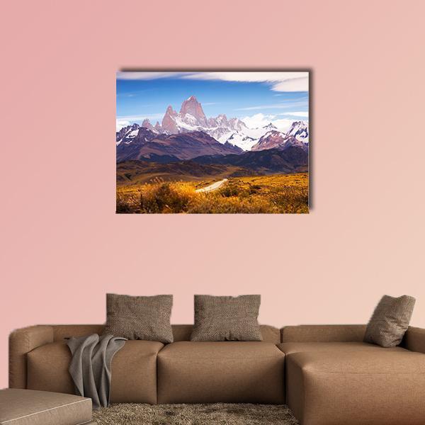 Snow-capped Mountain Road in Autumn Canvas Wall Art in brown, orange and blue, single panel hung on a wall