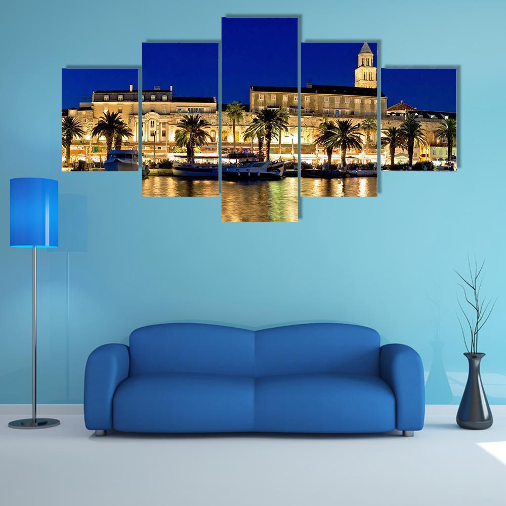 Evening Waterfront with Palm Trees and Boats Canvas Wall Art in gold, yellow and blue, 5 panel Star layout hung on a wall