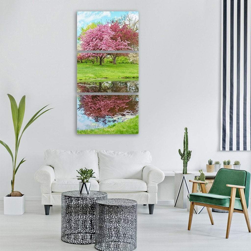 Pink Blossoming Tree Reflection Vertical Canvas Wall Art in green, blue and pink, hung on a wall
