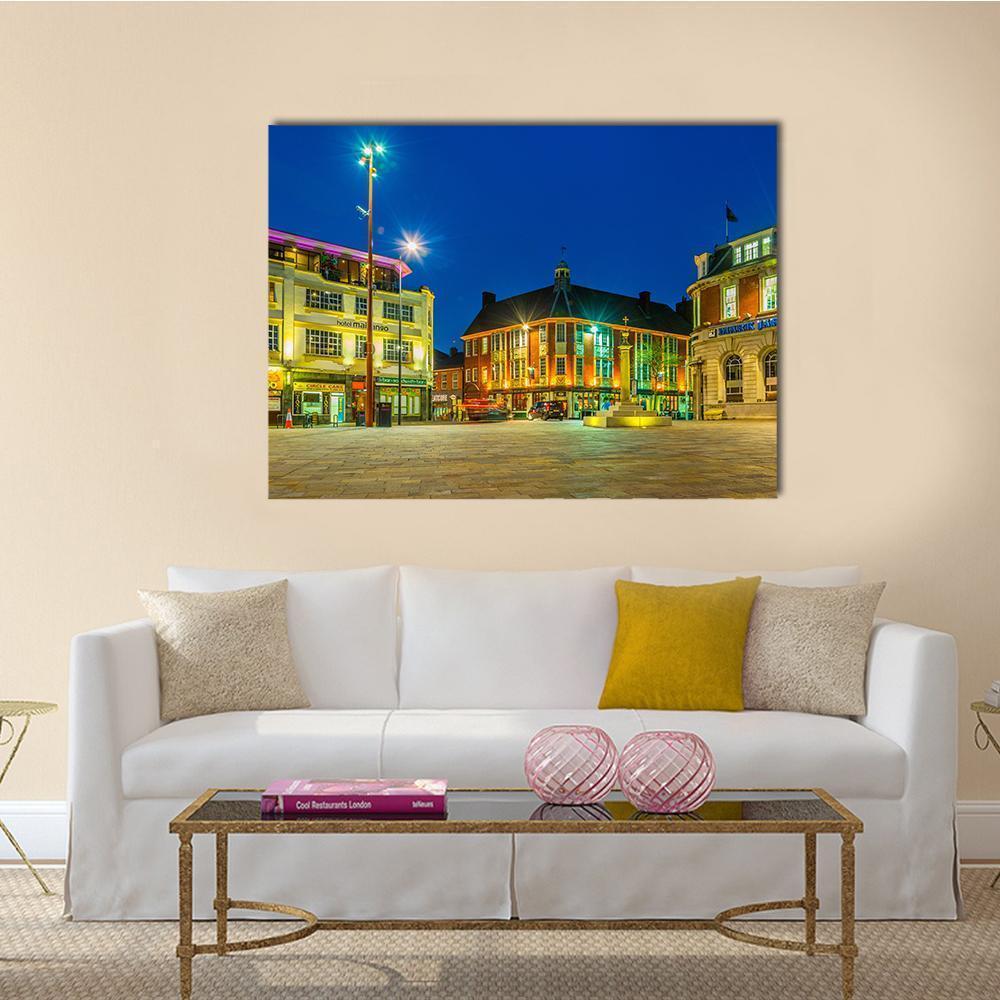 St Nicholas Square Leicester Night Cityscape Canvas Wall Art in yellow, blue and navy, single panel hung on a wall