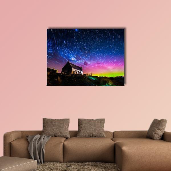 Church Under Star Trails and Aurora Canvas Wall Art in green, blue and purple, single panel hung on a wall