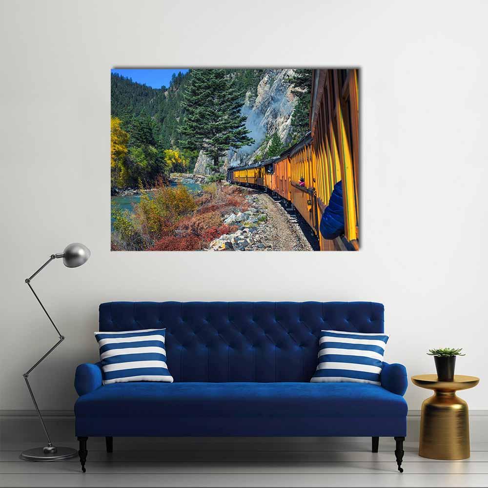 Yellow Steam Train Through Mountain Canyon Canvas Wall Art in yellow, green and blue, single panel hung on a wall