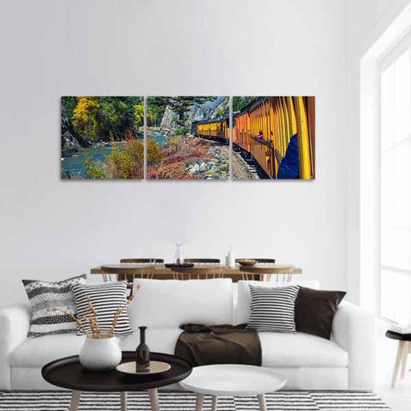 Vintage Yellow Train Through Mountain Canyon Panoramic Canvas Wall Art in yellow, green and blue, hung on a wall