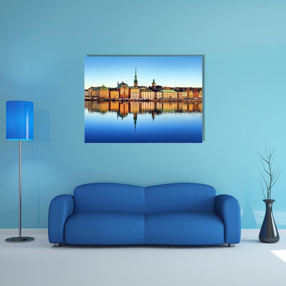 Stockholm Church Spire with Water Reflection Canvas Wall Art in orange, yellow and blue, single panel hung on a wall