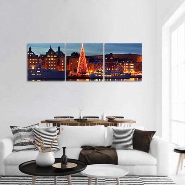 Historic Harbor with Illuminated Christmas Tree Panoramic Canvas Wall Art in orange, yellow and blue, hung on a wall