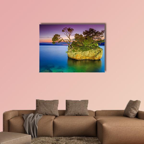 Rocky Island at Sunset Canvas Wall Art in orange, blue and purple, single panel hung on a wall