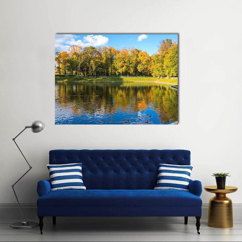Autumn Lake Reflections with Ducks Canvas Wall Art in orange, yellow and blue, single panel hung on a wall